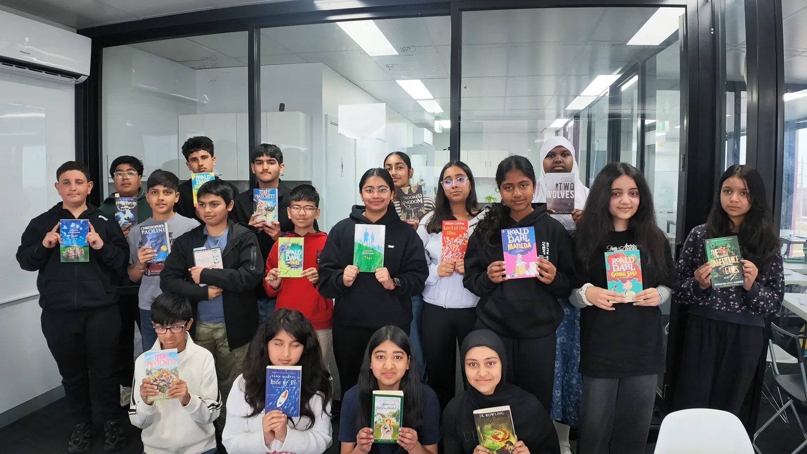Aspire students holding up the novels they are reading