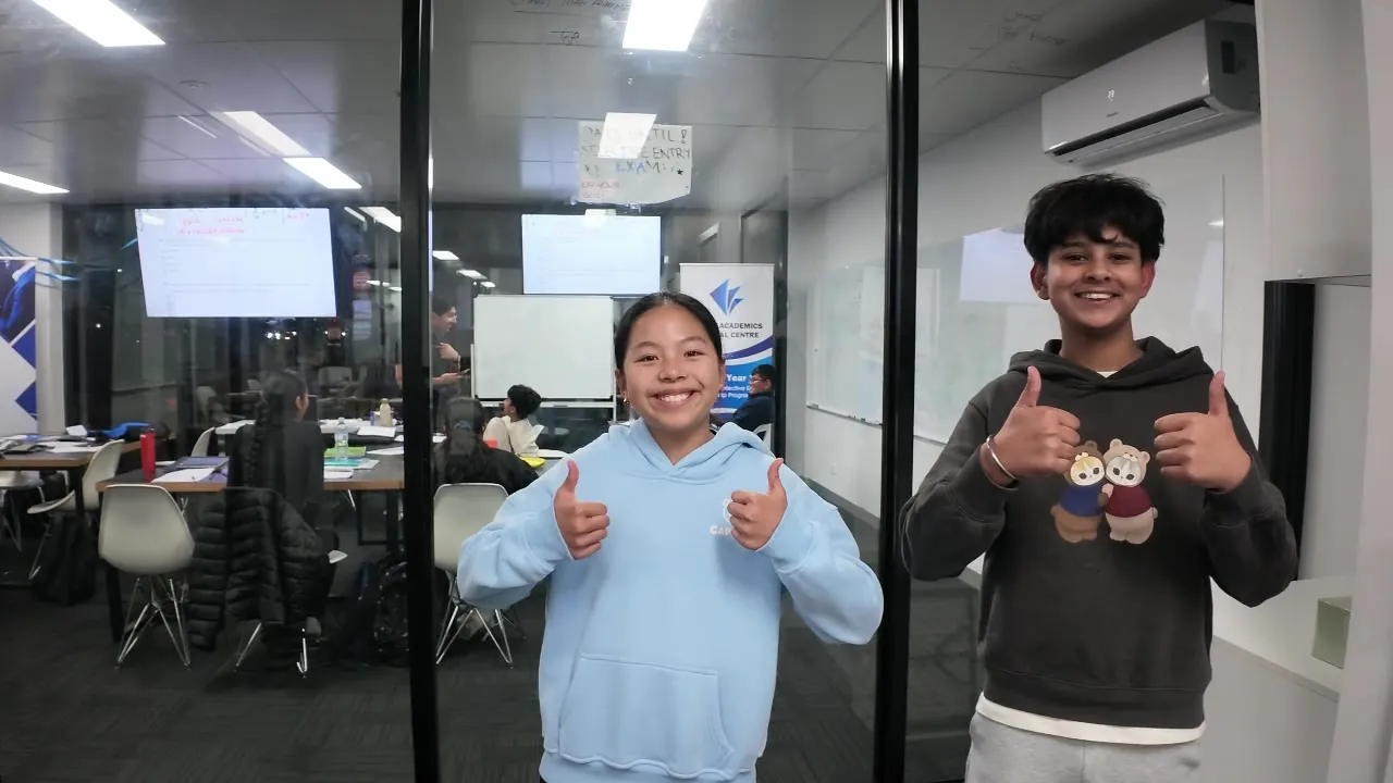 Two Aspire students giving a thumbs up in the classroom