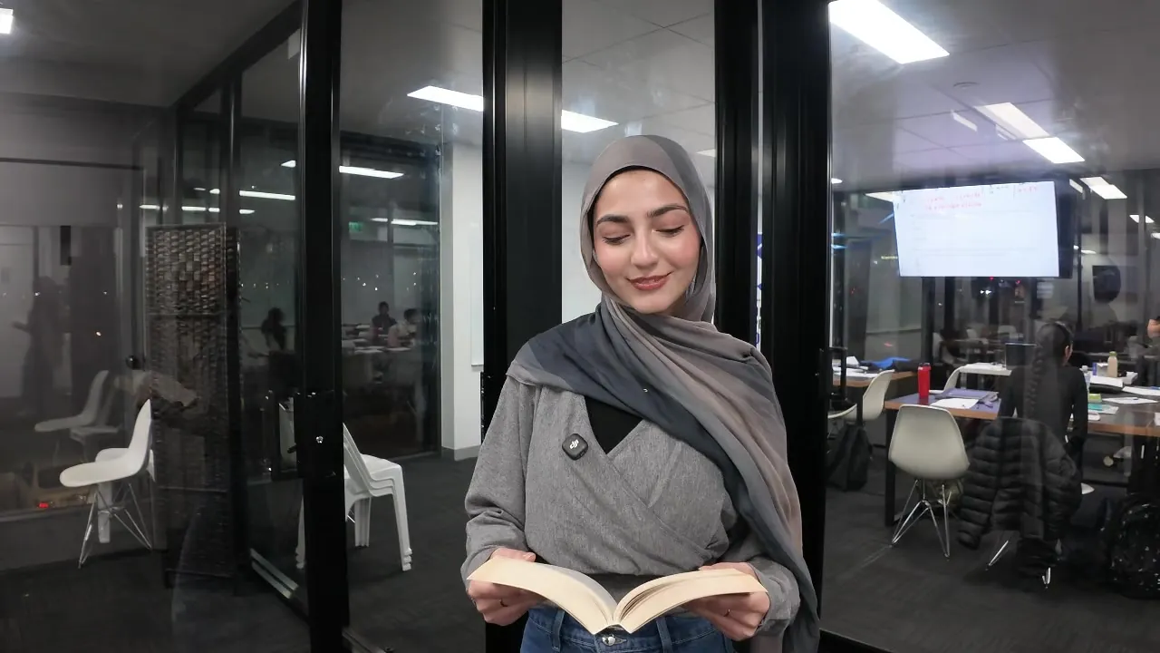 An Aspire tutor reading from a novel with a class working in the background